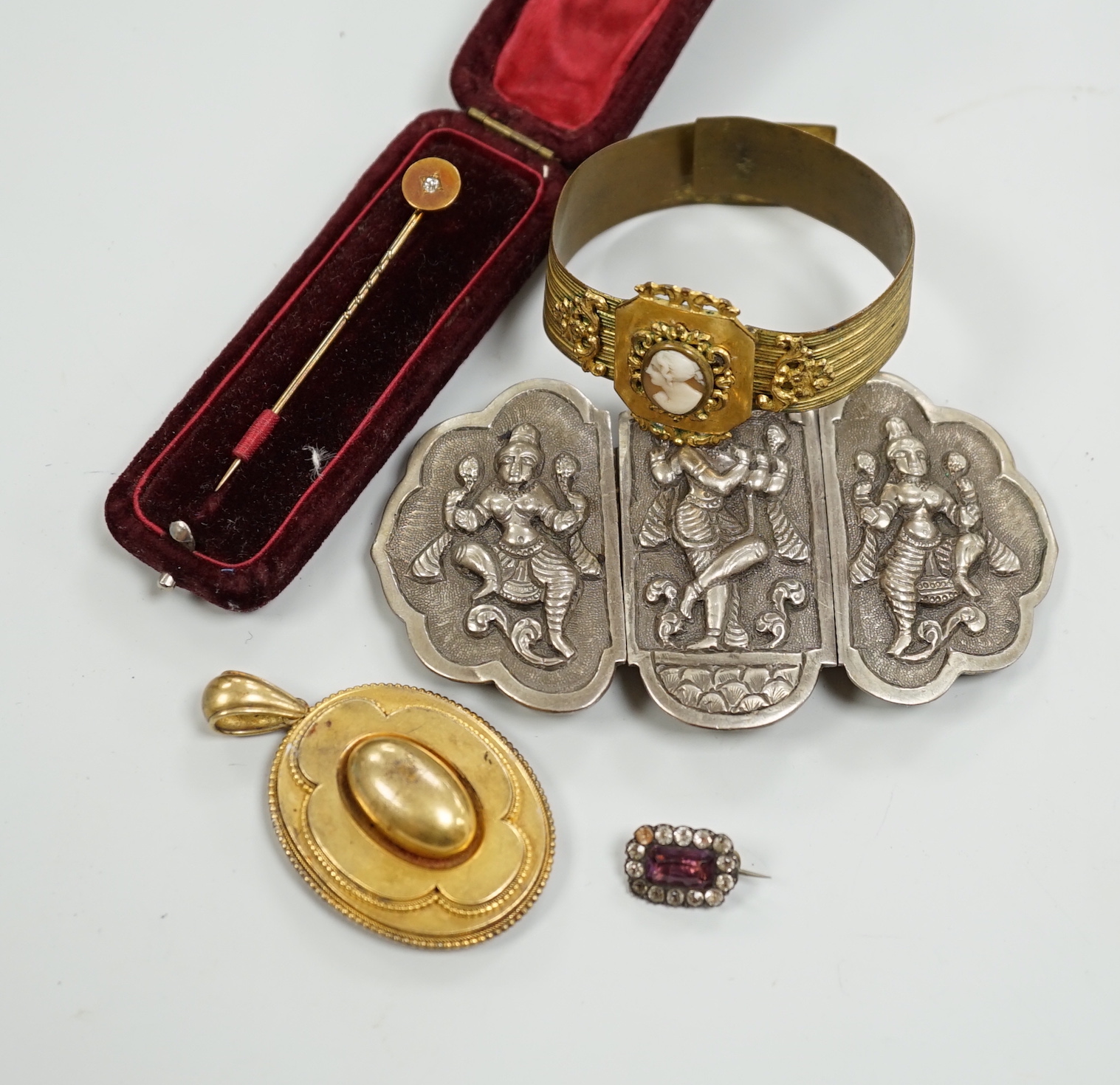 A Victorian yellow metal oval morning locket, with hair beneath a glazed panel verso, overall 56mm and four other items including a pinchbeck bangle.